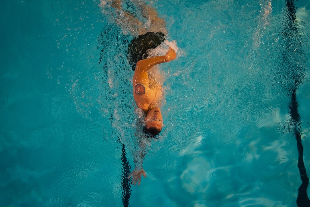 An overhead photo of a person swimming in a pool.