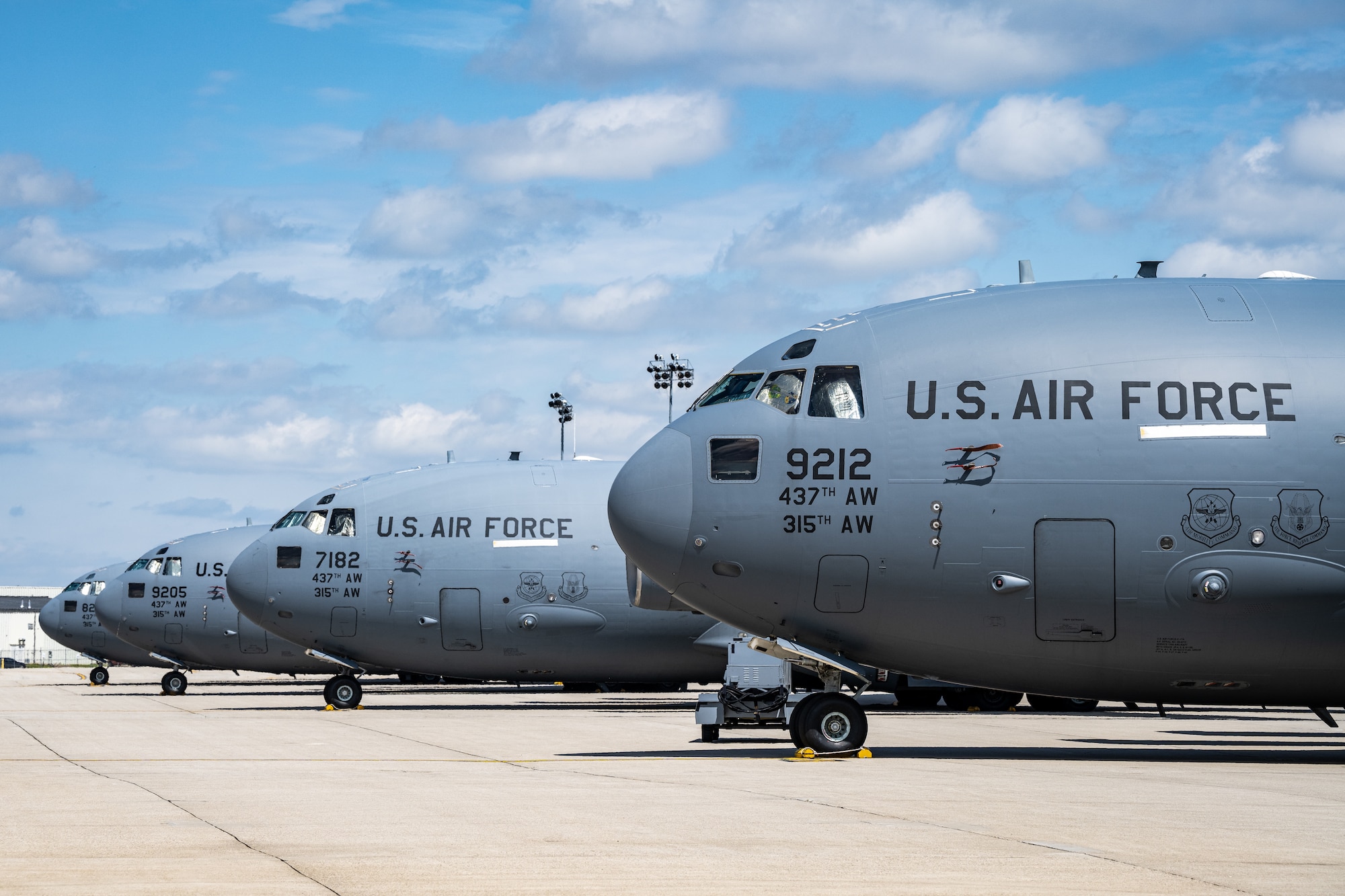 Side view of four C-17s parked side-by-side down the flightline