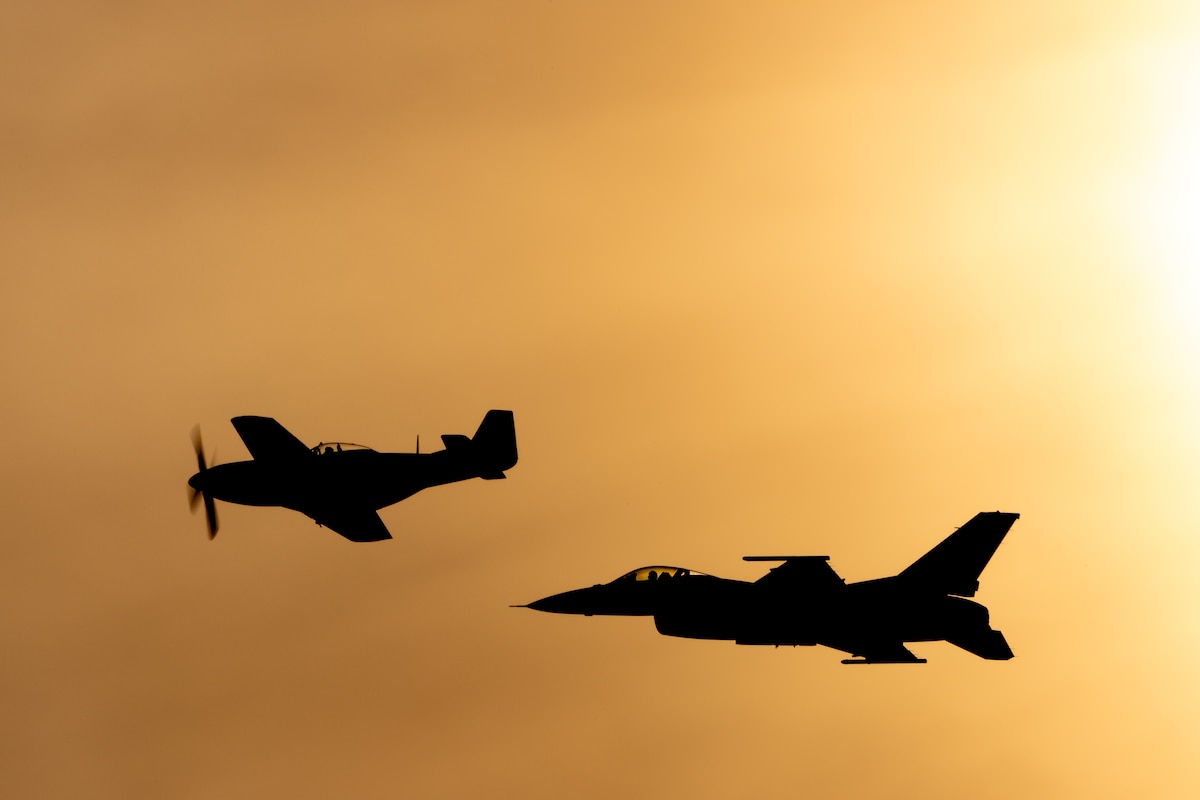 A vintage P-51 Mustang and a current F-16 Fighting Falcon cruise into the sunset during a heritage flight as part of the Thunder Over Louisville air show in Louisville, Ky., April 20, 2024. This year’s event featured more than 24 military and civilian aircraft, including the Kentucky Air National Guard’s C-130J Super Hercules. (U.S. Air National Guard photo by Dale Greer)