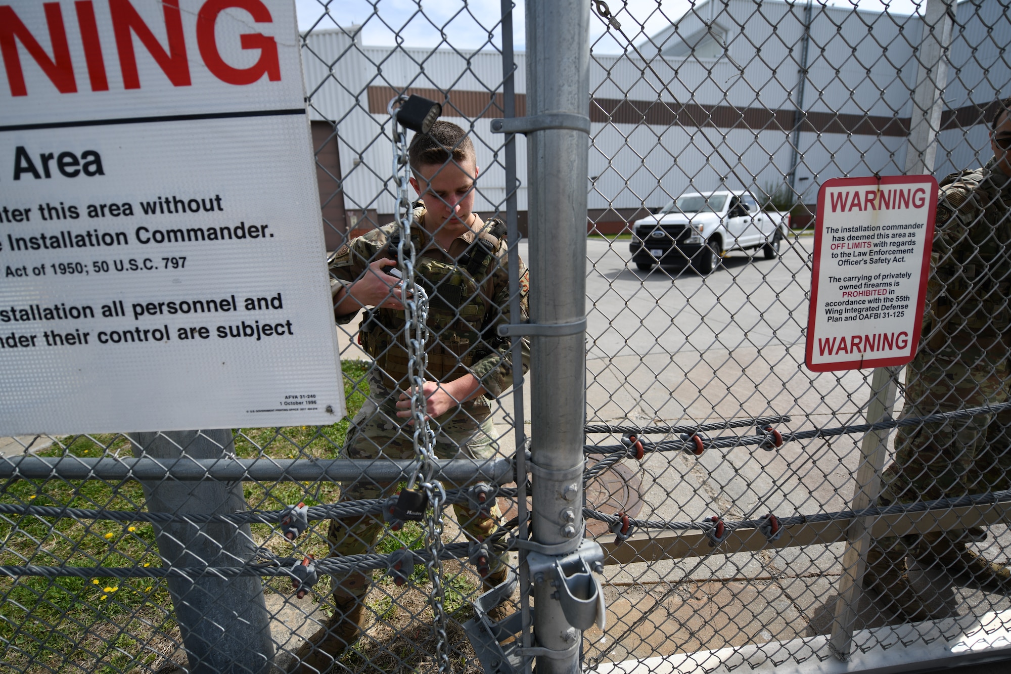 Airmen removing chain from a gate.