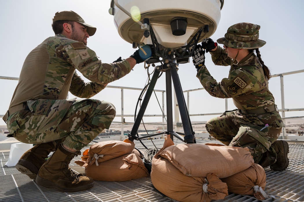 U.S. Air Force weather technicians assigned to the 379th Operations Support Squadron clean a weather radar system