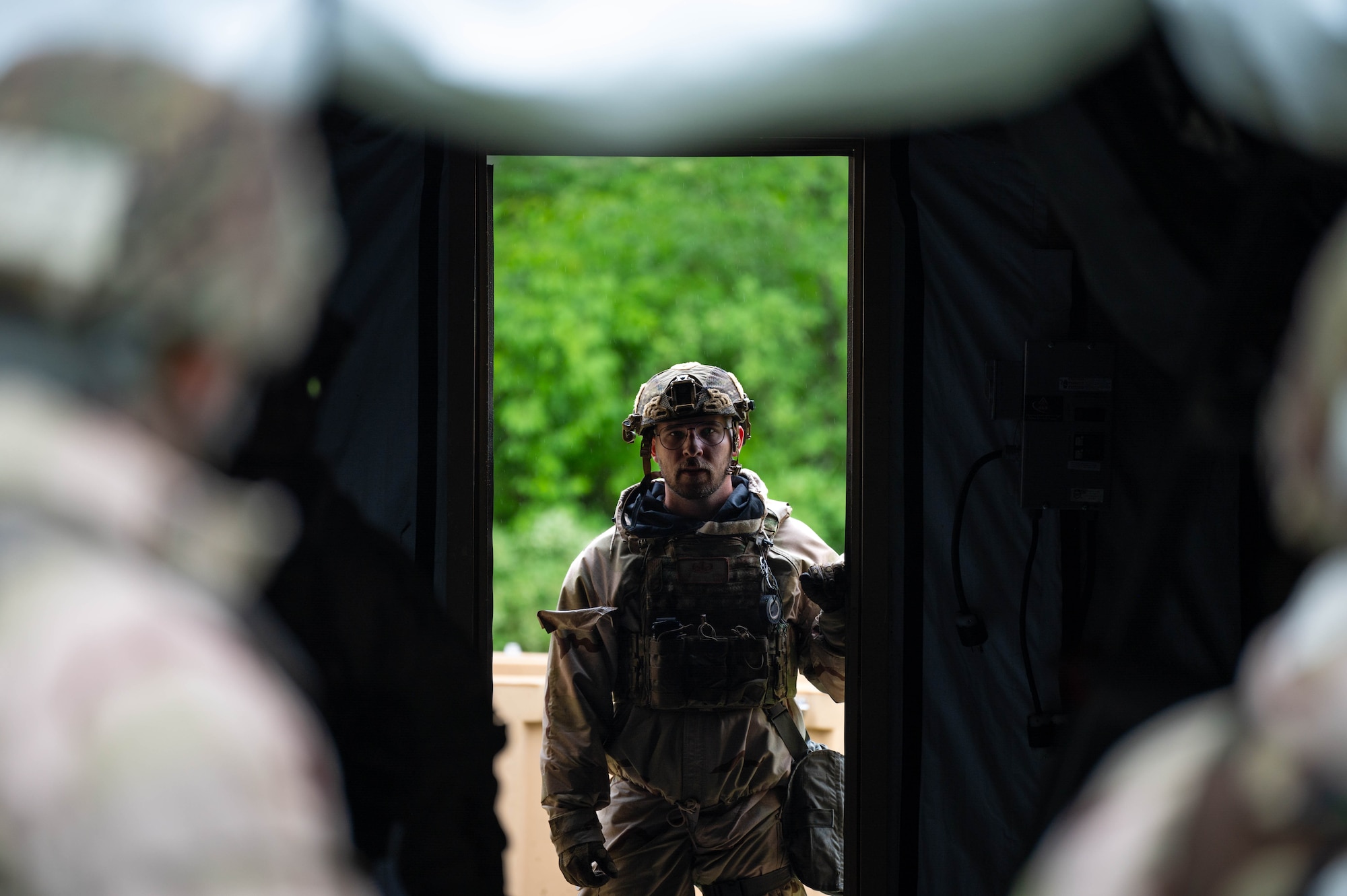 An Airman looks through the opening of a Small Shelter System tent.