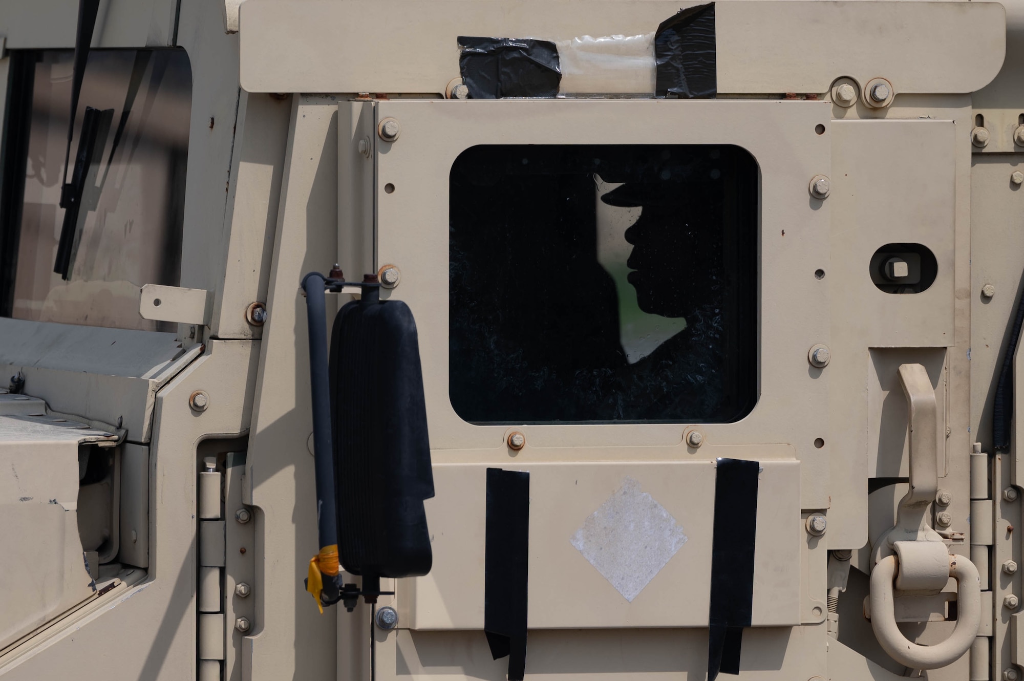 An Airman sits inside a High Mobility Multipurpose Wheeled Vehicle.