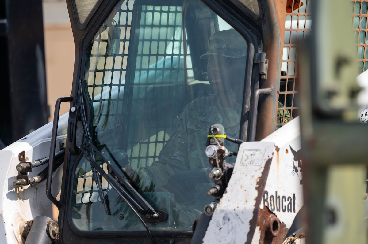 An Airman drives a Skid-Steer in preparation of Readiness Challenge X.