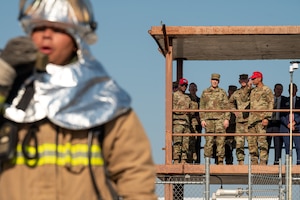Airmen watch fire fighters during an excercise