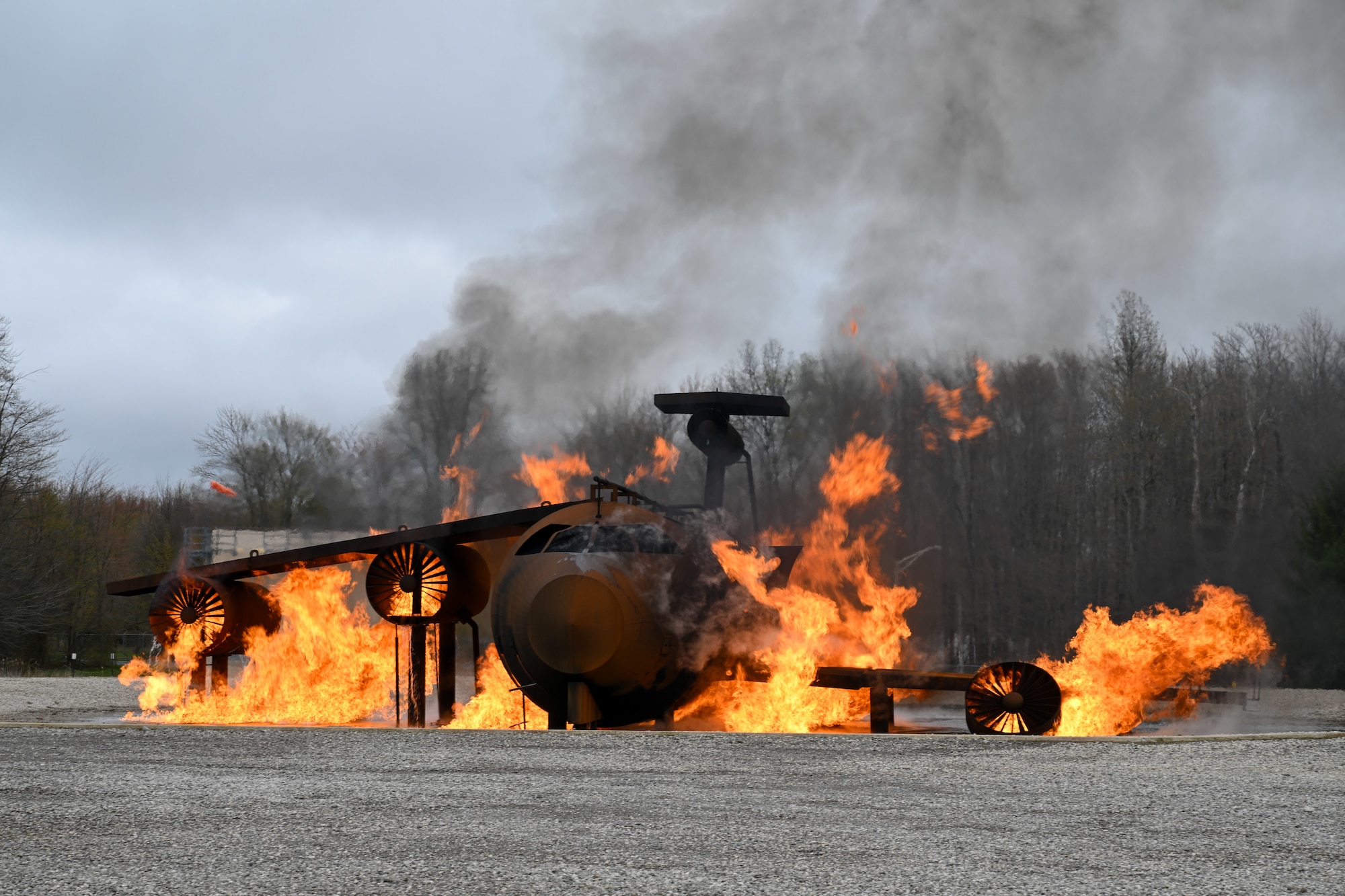 A mock aircraft crash is engulfed in flames at the firefighter training area as base firefighters respond during an exercise at Youngstown Air Reserve Station, Ohio, April 25, 2024.