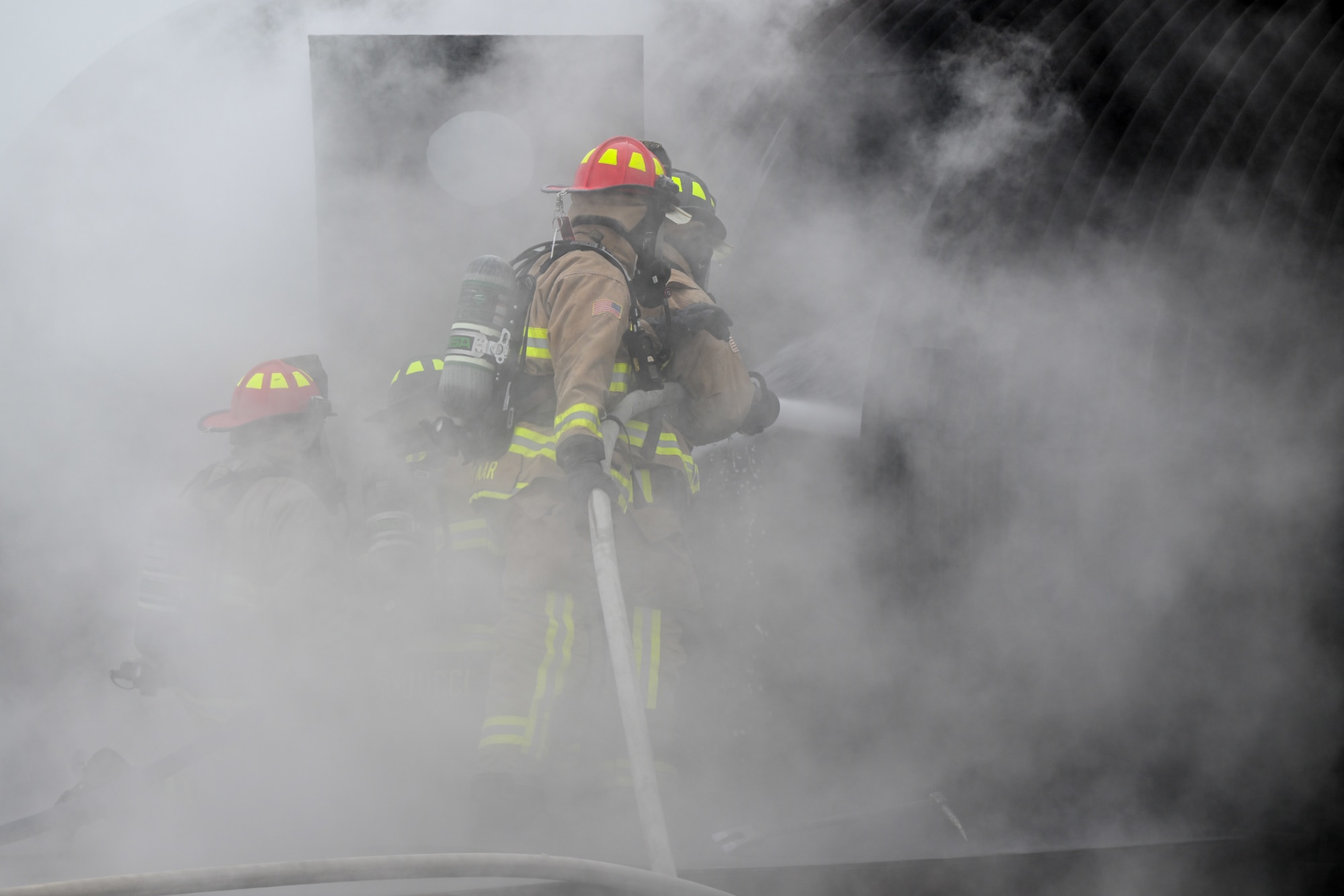 Youngstown Air Reserve Station firefighters breach the aircrew door while responding to a mock aircraft crash at the firefighter training area during an exercise at Youngstown Air Reserve Station, Ohio, April 25, 2024.