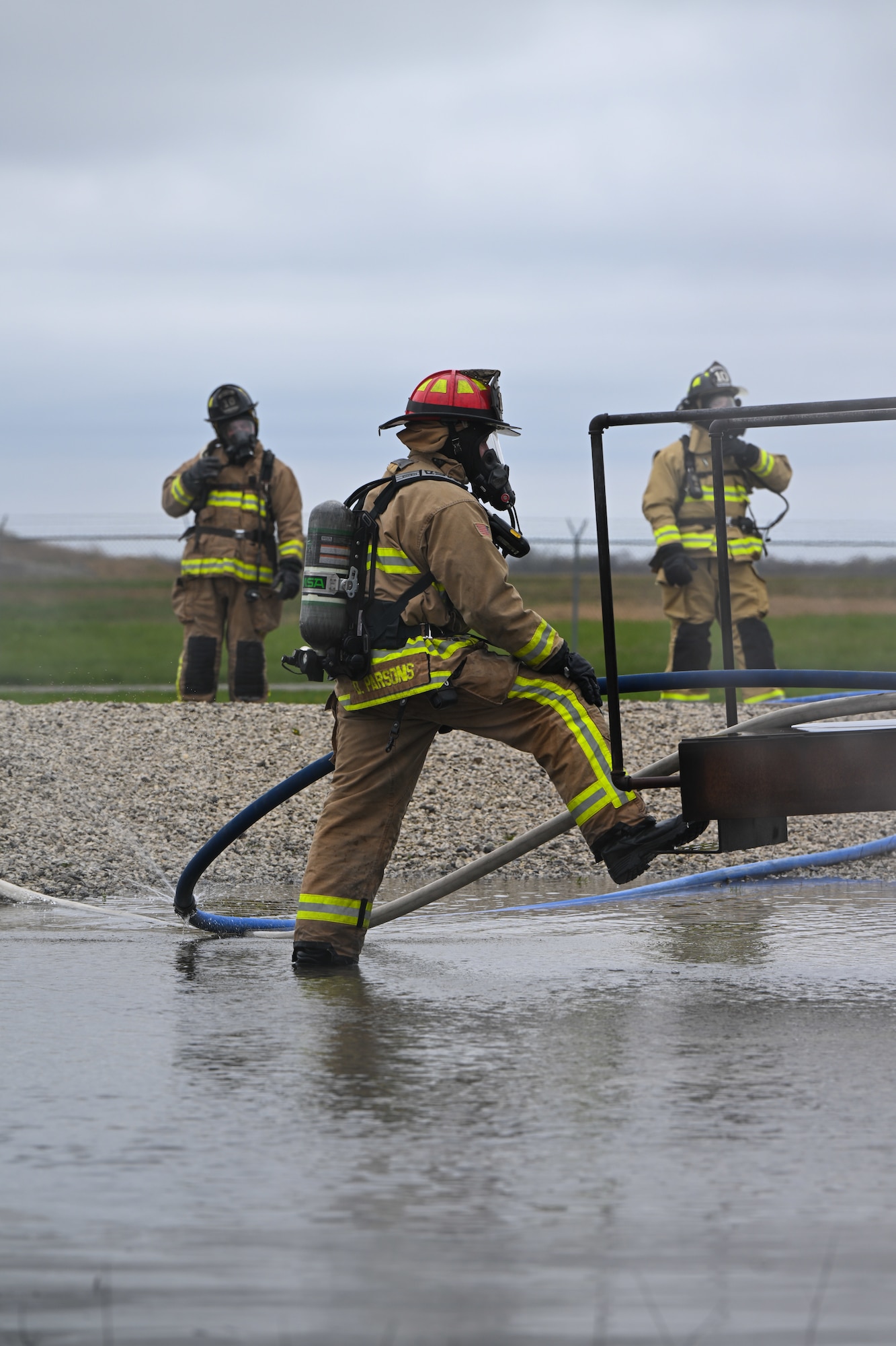 Youngstown Air Reserve Station fire captain Devon Parsons monitors a team of firefighters while responding to a mock aircraft crash at the firefighter training area during an exercise at Youngstown Air Reserve Station, Ohio, April 25, 2024.