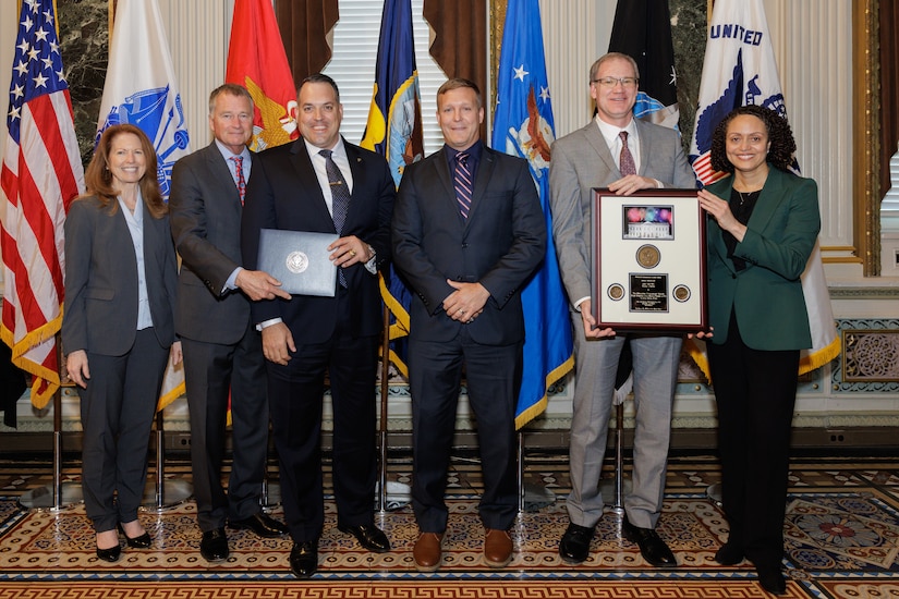 Group of people pose with an award.