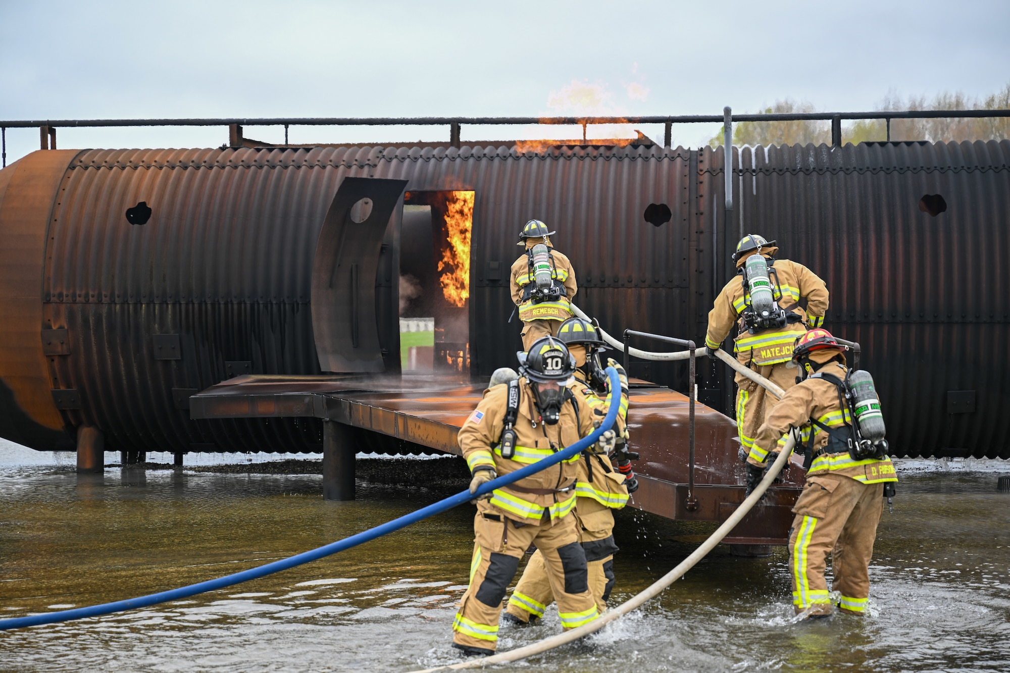 Youngstown Air Reserve Station firefighters approach the aircrew door while responding to a mock aircraft crash at the firefighter training area during an exercise at Youngstown Air Reserve Station, Ohio, April 25, 2024.