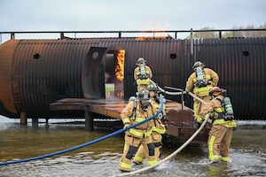 Youngstown Air Reserve Station firefighters approach the aircrew door while responding to a mock aircraft crash at the firefighter training area during an exercise at Youngstown Air Reserve Station, Ohio, April 25, 2024.