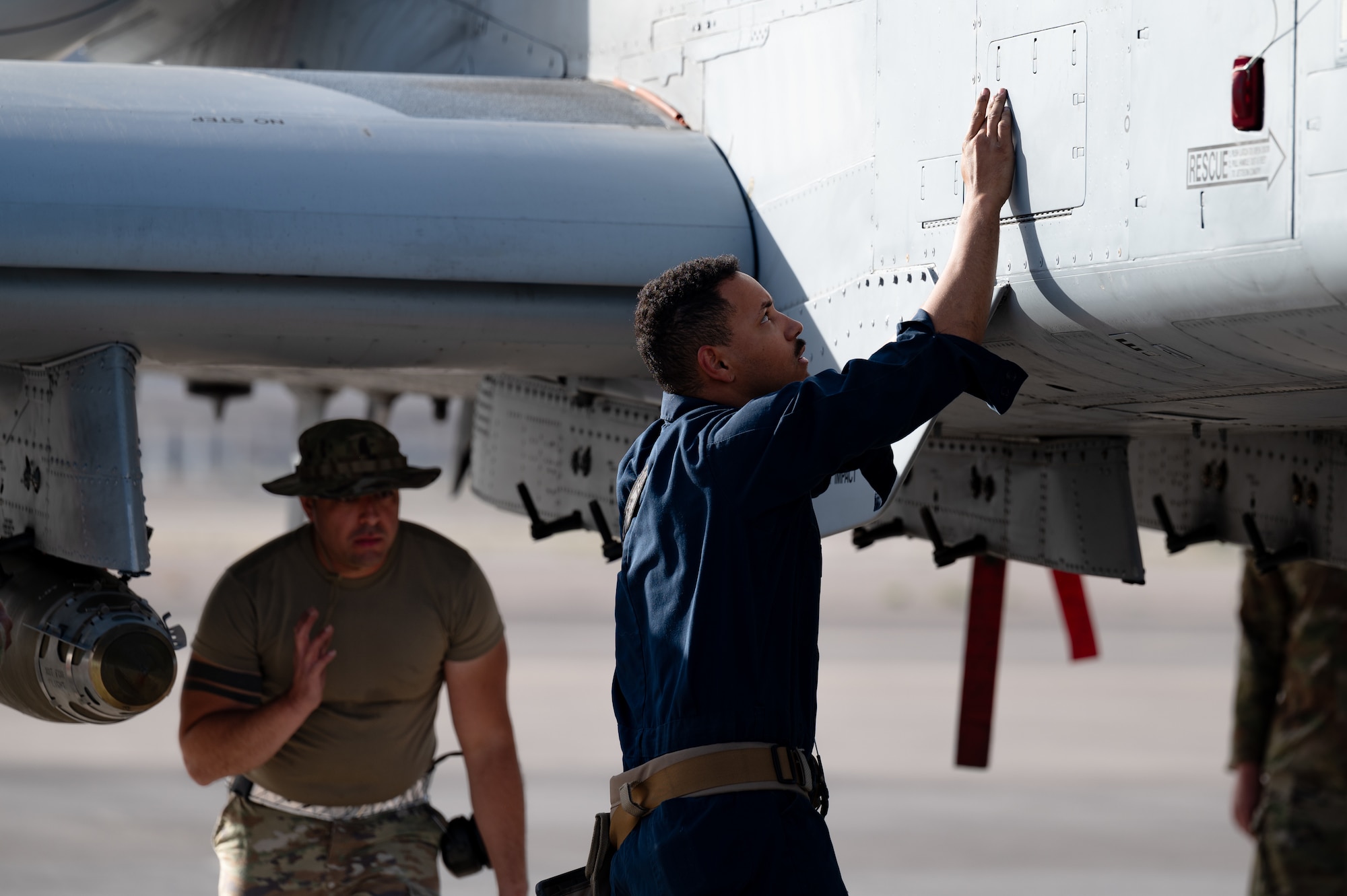 U.S. Air Force Senior Airman Christian Sevilla, left, a weapons load crew member assigned to the 757th Aircraft Maintenance Unit (AMXS), and Senior Airman Brandon Dickson, a weapons load crew member assigned to the 757th AMXS, check panels on an A-10 Warthog during a load competition at Nellis Air Force Base, Nevada, April 12, 2024.