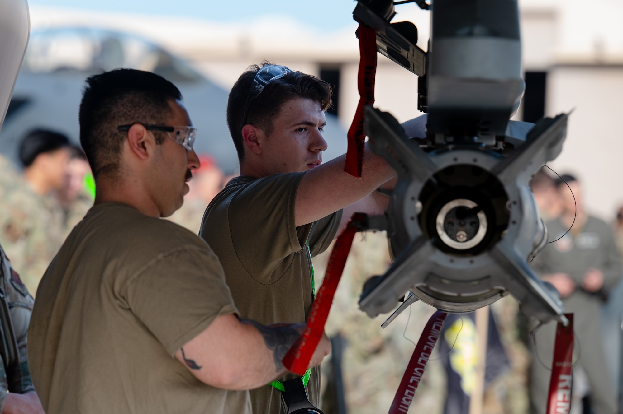 U.S. Air Force Staff Sgt. Luis Garcia, left, a weapons load crew chief assigned to the 57th Aircraft Maintenance Squadron (AMXS) Bolt Aircraft Maintenance Unit (AMU), and Airman Nicholas Rodriguez, a weapons load crew member assigned to the 57th AMXS Bolt AMU, check the munition on a F-35A Lightning II during a load competition at Nellis Air Force Base, Nevada, April 12, 2024.