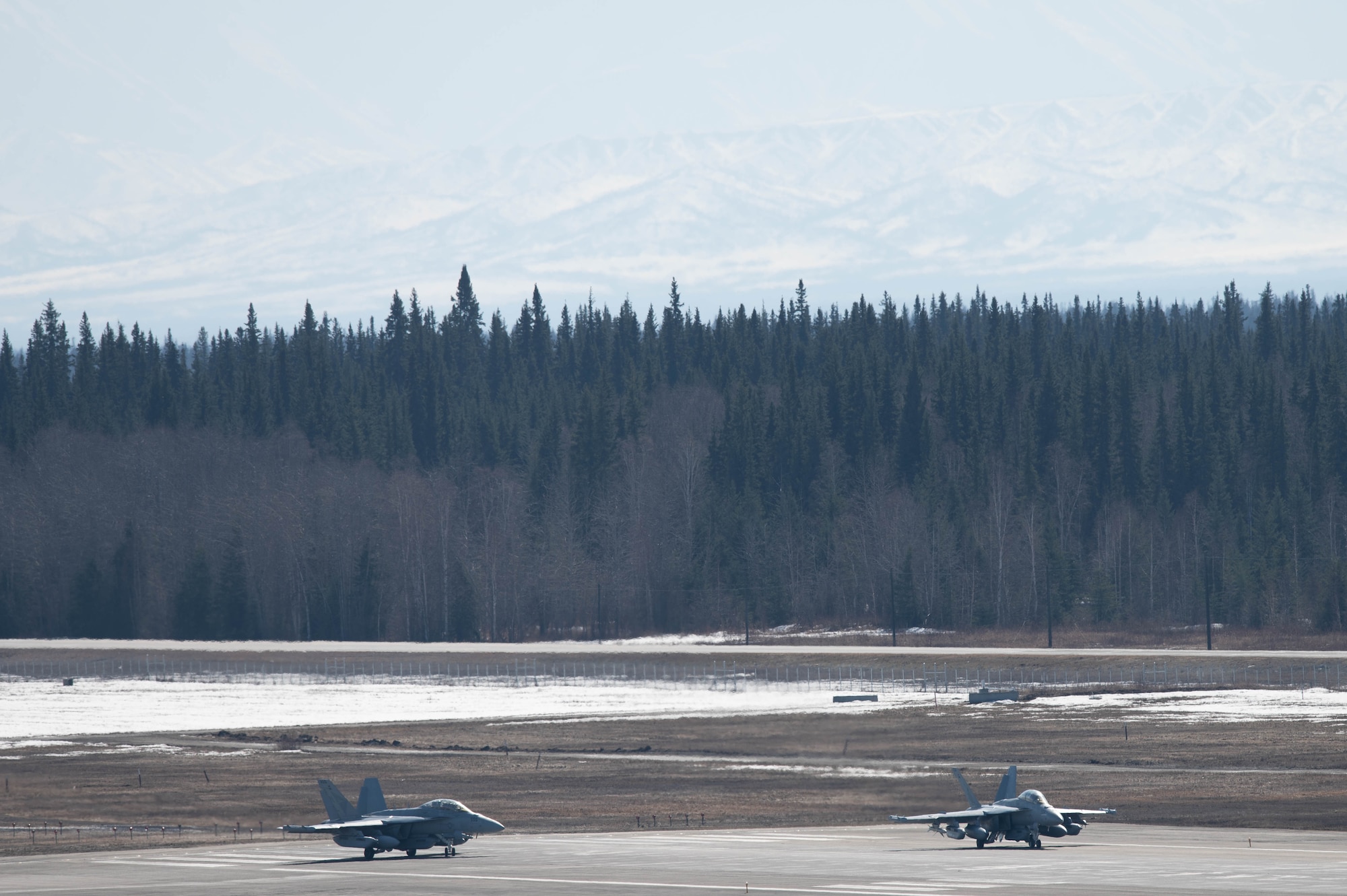 Two EA-18G Growlers assigned to the Electronic Attack Squadron (VAQ) 131 prepare to take off on the flightline.