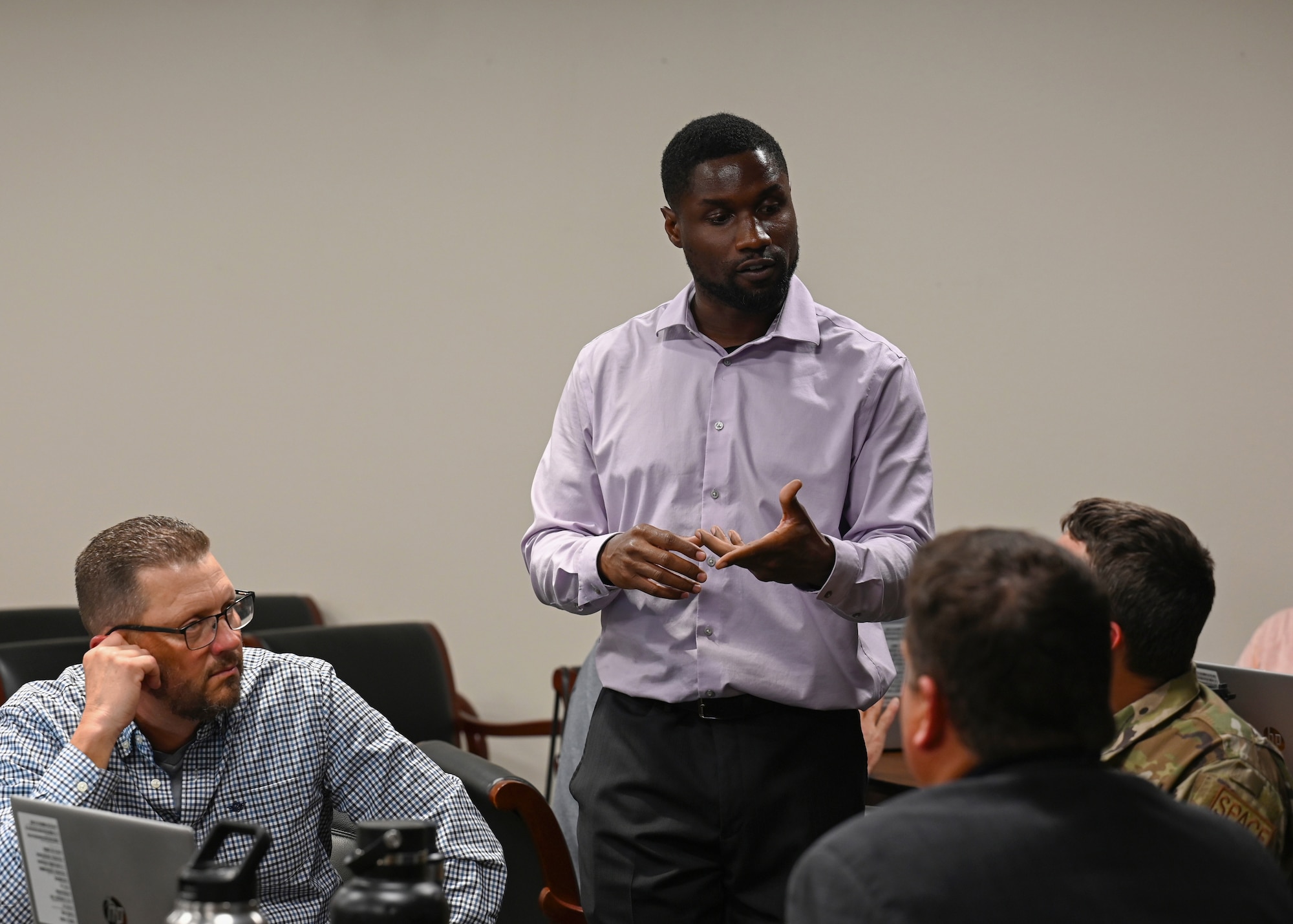 An instructor speaks to a team of three people.