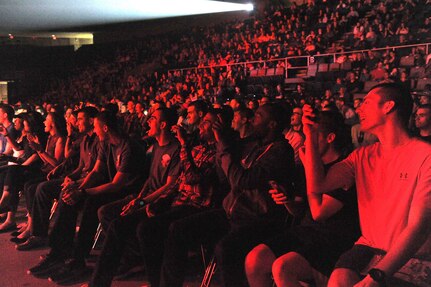 Venue packed with attendees under a red hue