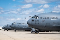 Side view of four C-17s parked side-by-side down the flightline
