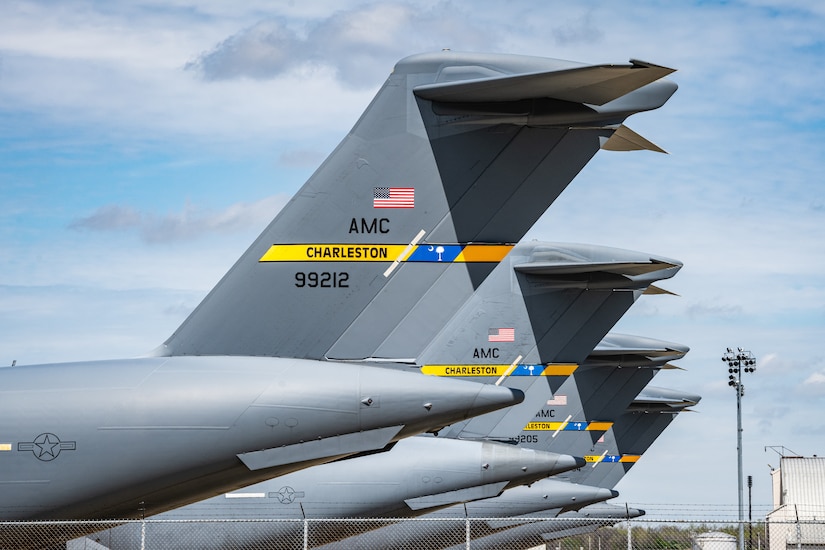 Side view of four C-17 tails parked side-by-side down the flightline