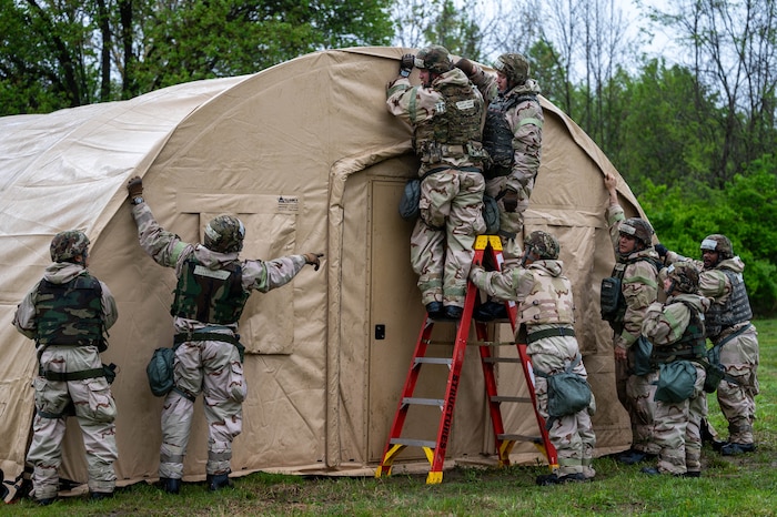 Airmen put up a Small Shelter System tent.