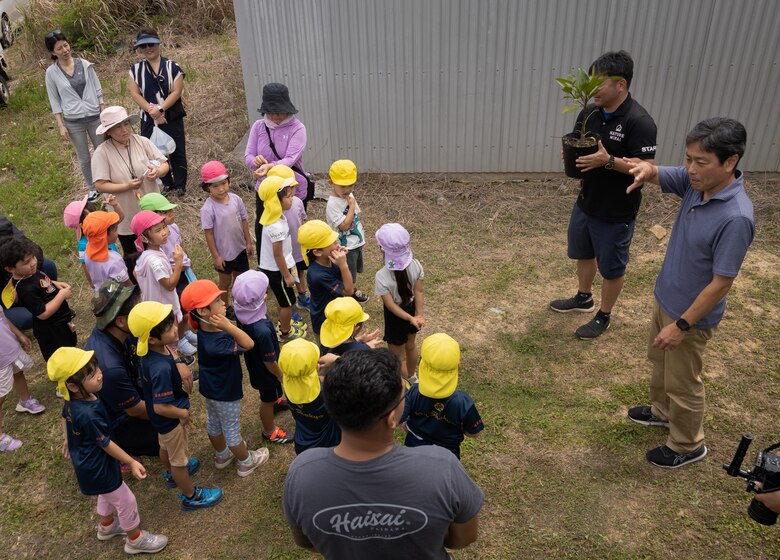 U.S. service members, local preschoolers, and Okinawa residents learn how to plant a mangrove tree during an Earth Day cleanup and tree-planting event at Nature Mirai Kan in Kin Town, Okinawa, Japan, April 22, 2024. Marine Corps Installations Pacific coordinated a week of Earth Day events to reinforce relationships between U.S. service members and the Okinawa community. The participants planted a total of 32 mangrove trees. (U.S. Marine Corps photo by Sgt. Maximiliano Rosas)