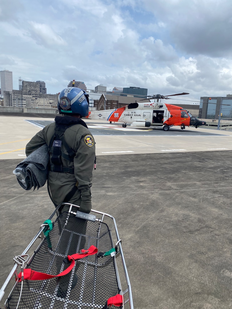 A Coast Guard Air Station New Orleans MH-60 Jayhawk helicopter aircrewman carries a Stokes litter back to the aircraft at University Medical Center in New Orleans, Louisiana, April 27, 2024.