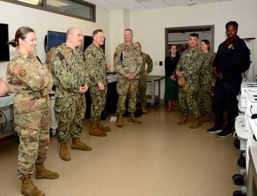U.S. Navy Capt. Cory Gaconnet, Naval Medical Center San Diego's Bioskills and Simulation Training Center department head, third from left, speaks to Uniformed Services University of Health Science Brigade leadership and team members during a visit and tour at NMCSD, April 24, 2024. Navy Medicine Readiness and Training Command San Diego’s mission is to prepare service members to deploy in support of operational forces, deliver high quality healthcare services and shape the future of military medicine through education, training and research. NMRTC San Diego employs more than 6,000 active duty military personnel, civilians and contractors in Southern California to provide patients with world-class care anytime, anywhere. (U.S. Navy photo by Mass Communication Specialist 2nd Celia Martin)