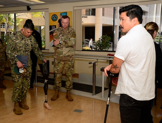 Nathaniel Leoncio, Naval Medical Center San Diego's Comprehensive Combat and Complex Casualty Care department's prosthetist, right, speaks to Uniformed Services University of Health Science Brigade leadership and team members in the prosthetics center during a visit and tour at NMCSD, April 24, 2024. Navy Medicine Readiness and Training Command San Diego’s mission is to prepare service members to deploy in support of operational forces, deliver high quality healthcare services and shape the future of military medicine through education, training and research. NMRTC San Diego employs more than 6,000 active duty military personnel, civilians and contractors in Southern California to provide patients with world-class care anytime, anywhere. (U.S. Navy photo by Mass Communication Specialist 2nd Celia Martin)