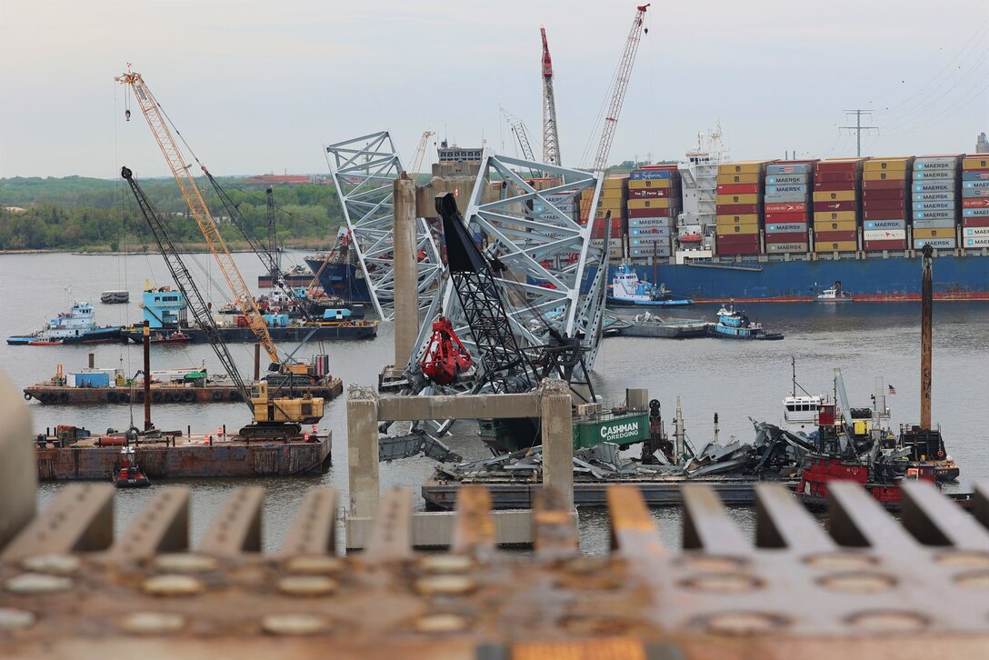 A large number of floating cranes can be seen at the site of the Francis Scott Key Bridge collapse. The MV Dali, the container ship which struck the bridge, is visible in the distance.