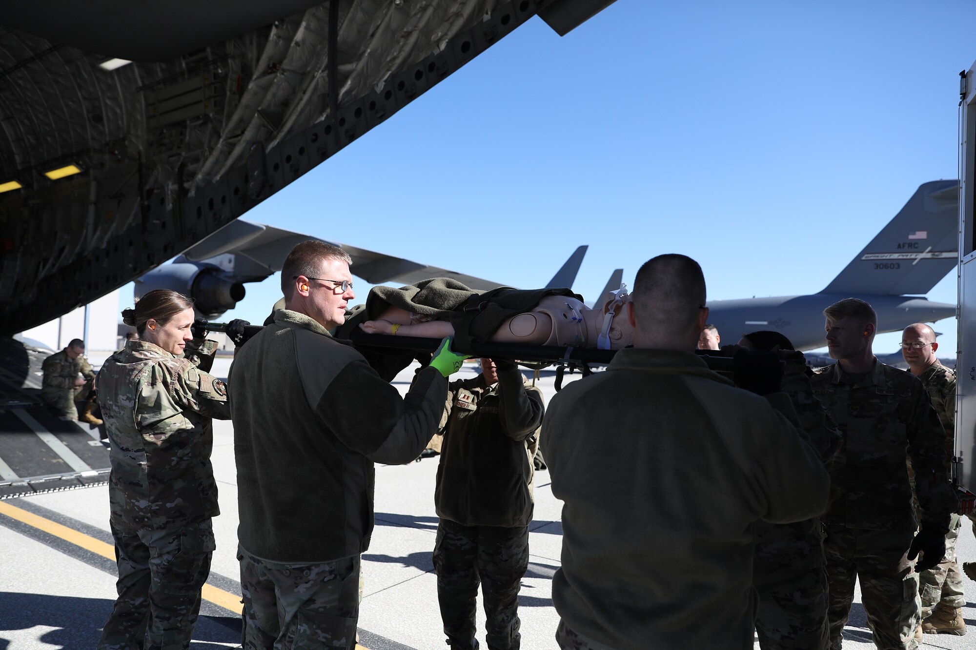 Members of the 445th Aeromedical Staging Squadron unload a manikin from an Ambus onto a C-17 Globemaster III during launch and recovery training exercise with 445th Aeromedical Evacuation Squadron Airmen at Wright-Patterson Air Force Base, Ohio, April 6, 2024.