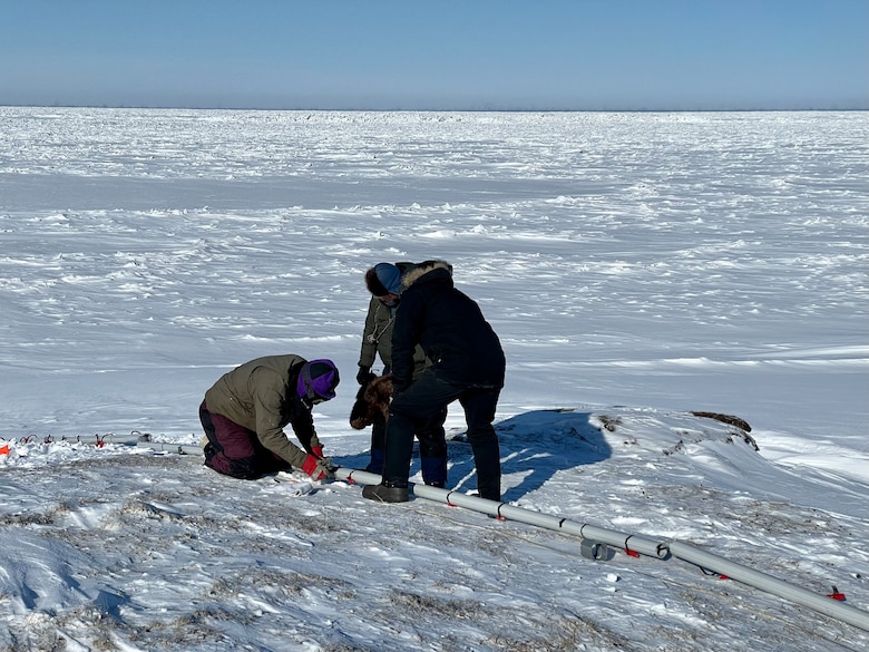 ERDC Cold Regions Research and Engineering Laboratory researchers Art Gelvin, Brad Baxter and Jon Maakestad cut through ice and snow to install cable, conduit and ground contact points for a time-lapse electrical resistivity tomography array. The trio was part of the joint Integrated Support for Operations in Polar Seas project that conducted fieldwork in Utqiagvik, Alaska.