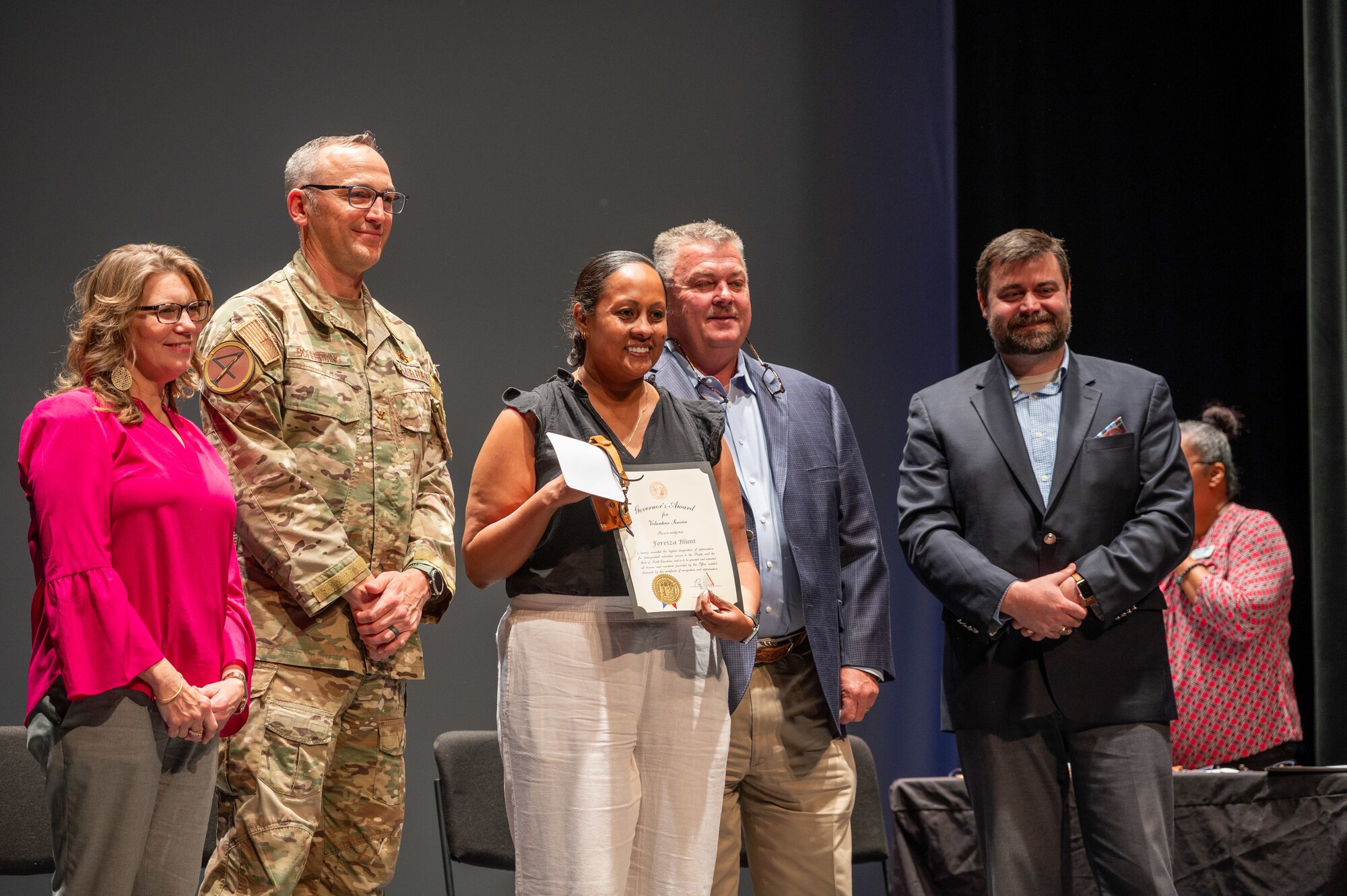 U.S. Air Force Col. Steven Bofferding, 4th Fighter Wing deputy commander, and Goldsboro city local leaders award Fareiza Blunt, Seymour Johnson Air Force Base Resilience Training Assistance program director, with the Governor's Award for volunteer service during a volunteer award ceremony at the Paramount Theatre in Goldsboro, North Carolina, April 16, 2024. Local volunteers convened at the Paramount Theatre for “A Night Full of Heroes Volunteer Ceremony” where they were celebrated and honored by the United Way of Wayne County. (U.S. Air Force photo by Airman 1st Class Leighton Lucero)
