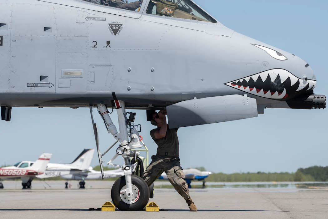 A person working on the undercarriage of an A-10C.