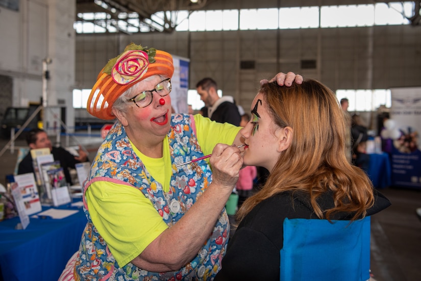 Nancy “Antsy the Clown” Devito, Joint Base McGuire-Dix-Lakehurst Honorary Commander Emeritus, paints an attendee’s face during Bring Your Child to Work Day at JB MDL, N.J., April 25, 2024. The event highlights the JB MDL mission to children during the Month of the Military Child. (U.S. Air Force photo by Jewaun Victor)