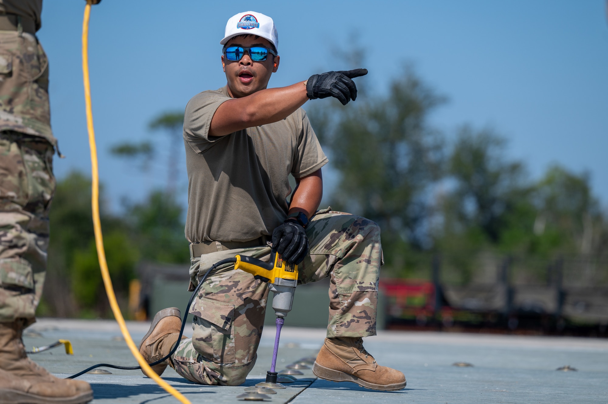 U.S. Air Force Airman 1st Class Rommel Angeles, 45th Civil Engineer Squadron heavy equipment operator, gives instruction to a teammate during a fiber reinforced polymer matting installation event at Readiness Challenge X at Tyndall Air Force Base, Florida, April 25, 2024. Readiness Challenge X was a multi-day competition between teams of civil engineering squadrons from around the world that tested unit readiness, strengthened camaraderie and sharpened skills through joint training in a simulated contested environment. (U.S. Space Force photo by Airman 1st Class Spencer Contreras)