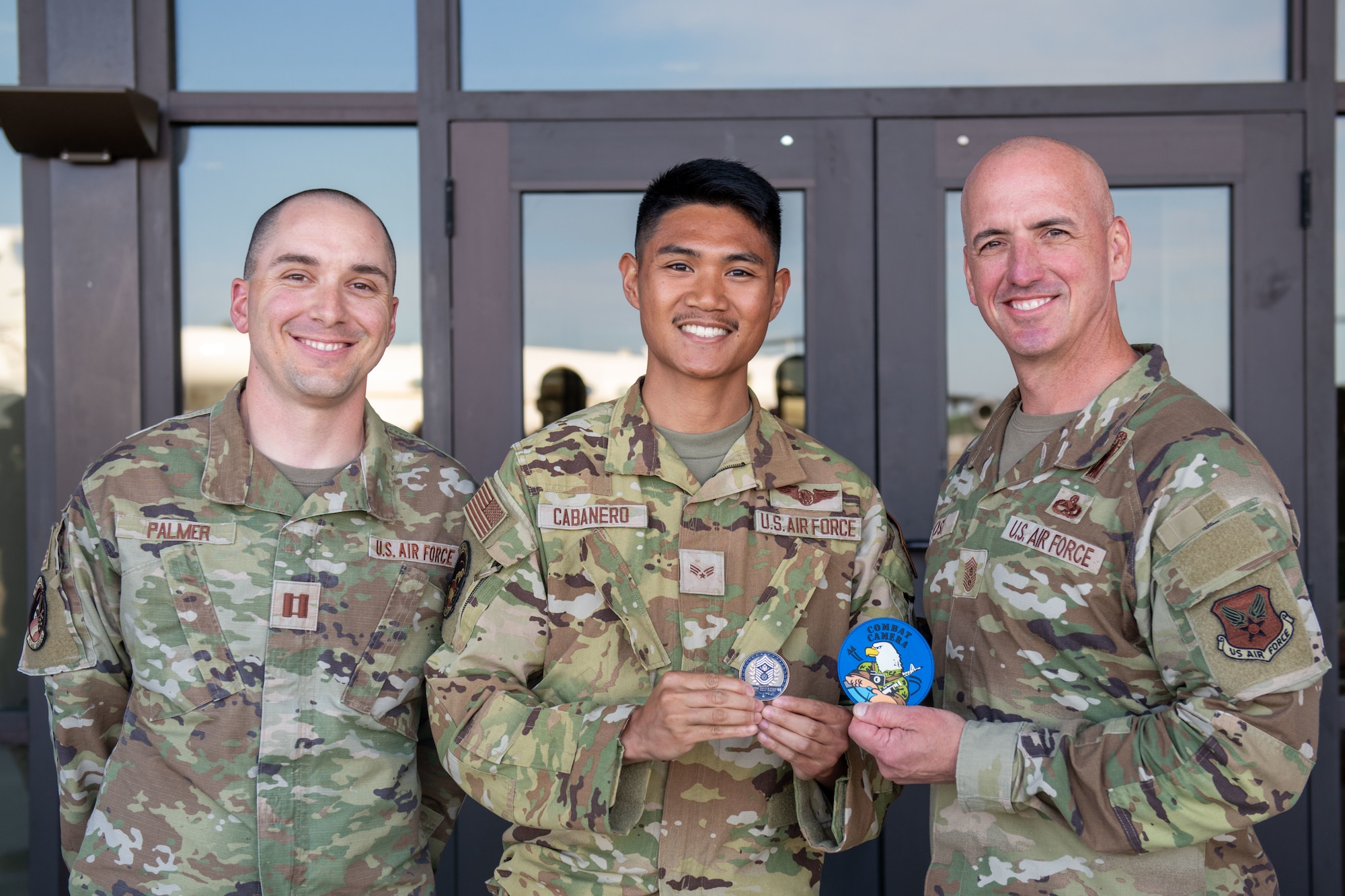 Chief Master Sgt. of the Air Force David Flosi, right, Senior Airman Jacob Cabanero, 1st Combat Camera squadron aerial combat camera journeyman, middle, and Capt. Allen Palmer, 1st Combat Camera squadron flight commander, pose for a photo at Joint Base Charleston, South Carolina, April 26, 2024. U.S. Air Force Chief of Staff Gen. David Allvin and Flosi visited JB Charleston to meet with Airmen, recognize outstanding performers, and host an all call to discuss Air Force reoptimization. (U.S. Air Force photo by Senior Airman Christian Silvera)