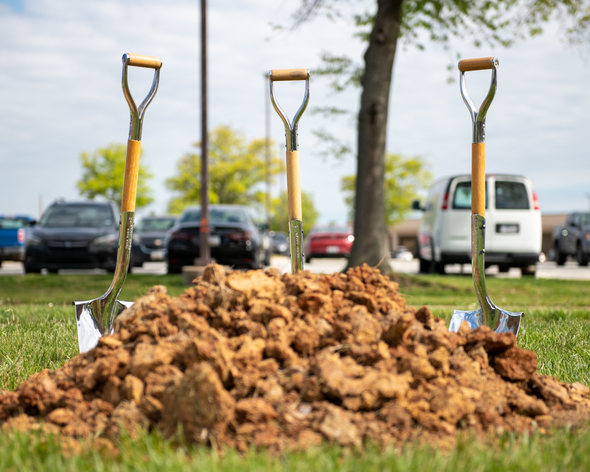 Shovels placed in dirt for the tree planting ceremony at the Base Theater.