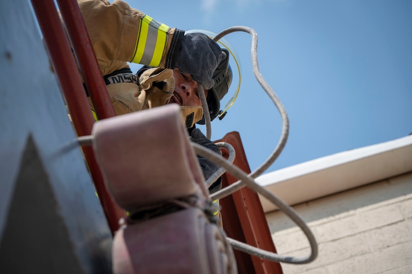 A photo of a firefighter pulling ropes.