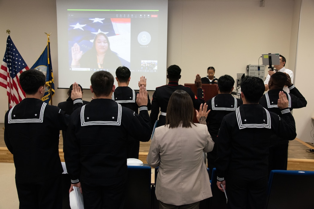 Rebecca Maliuwelur, United States Citizenship and Immigration Services Guam field office director, administers the Oath of Allegiance remotely during a naturalization ceremony hosted by Region Legal Service Office Western Pacific, onboard Commander, Fleet Activities Yokosuka (CFAY) at the AOB Auditorium.