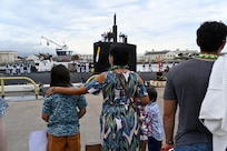The family of a Sailor from the Los Angeles-class fast-attack submarine USS Topeka (SSN 754) waits on the pier as the submarine returns to Joint Base Pearl Harbor-Hickam after completing a deployment, Nov. 30. (U.S. Navy photo by Cmdr. Amelia Umayam)
