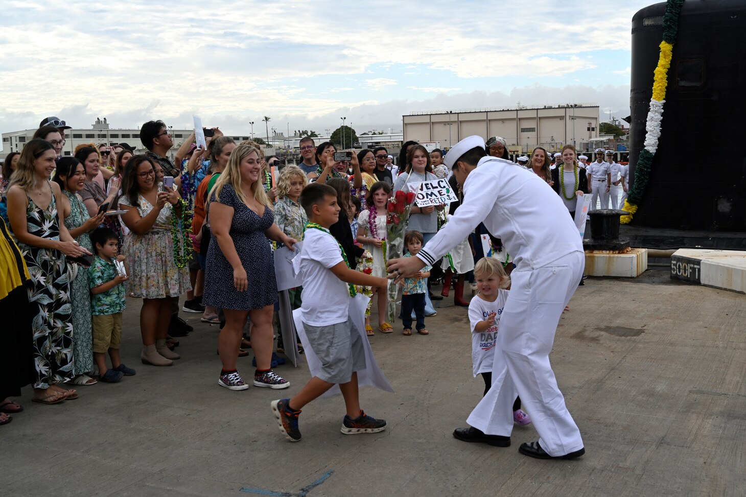 A Sailor from the Los Angeles-class fast-attack submarine USS Topeka (SSN 754) hugs his family onboard Joint Base Pearl Harbor-Hickam after returning from deployment, Nov. 30. (U.S. Navy photo by Cmdr. Amelia Umayam)