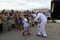 A Sailor from the Los Angeles-class fast-attack submarine USS Topeka (SSN 754) hugs his family onboard Joint Base Pearl Harbor-Hickam after returning from deployment, Nov. 30. (U.S. Navy photo by Cmdr. Amelia Umayam)