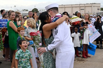 A Sailor from the Los Angeles-class fast-attack submarine USS Topeka (SSN 754) hugs his family onboard Joint Base Pearl Harbor-Hickam after returning from deployment, Nov. 30. (U.S. Navy photo by Cmdr. Amelia Umayam)