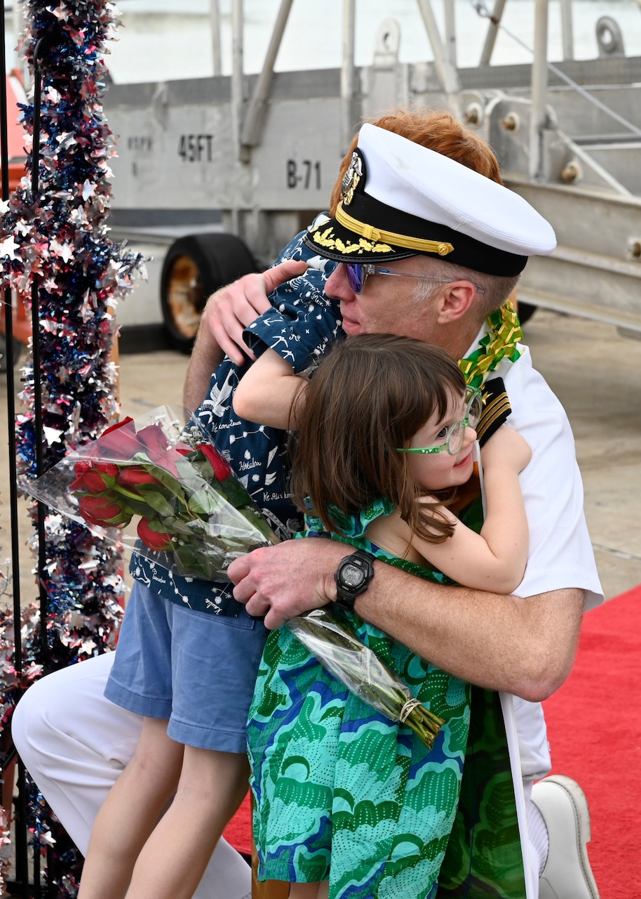 Cmdr. James Fulks, commanding officer of the Los Angeles-class fast-attack submarine USS Topeka (SSN 754) hugs his family onboard Joint Base Pearl Harbor-Hickam after returning from deployment, Nov. 30. (U.S. Navy photo by Cmdr. Amelia Umayam)