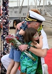 Cmdr. James Fulks, commanding officer of the Los Angeles-class fast-attack submarine USS Topeka (SSN 754) hugs his family onboard Joint Base Pearl Harbor-Hickam after returning from deployment, Nov. 30. (U.S. Navy photo by Cmdr. Amelia Umayam)