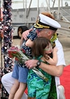 Cmdr. James Fulks, commanding officer of the Los Angeles-class fast-attack submarine USS Topeka (SSN 754) hugs his family onboard Joint Base Pearl Harbor-Hickam after returning from deployment, Nov. 30. (U.S. Navy photo by Cmdr. Amelia Umayam)