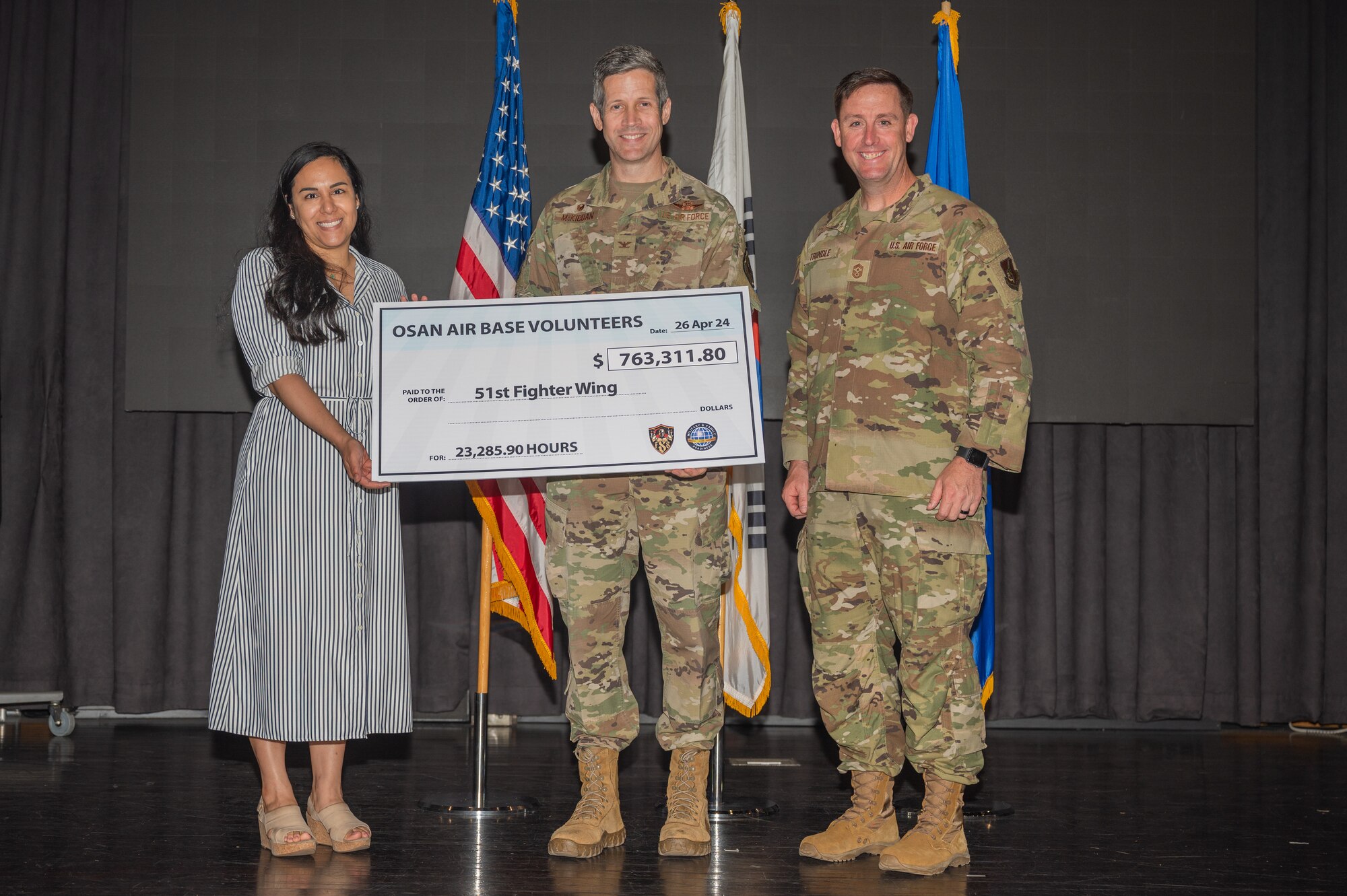 The 51st Fighter Wing command team presents a check representing the total value of volunteer services donated throughout 2023, during a volunteer appreciation event at Osan Air Base, Republic of Korea, April 26, 2024. The combined volunteer efforts of Airmen and personnel at Osan AB exceeded 23,000 hours and was valued at over $760,000 of time. (U.S. Air Force photo by Airman 1st Class Chase Verzaal)