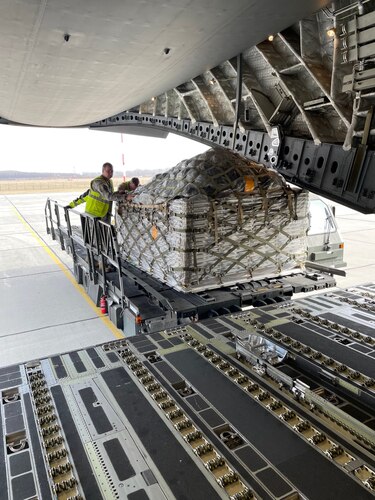 Heavy Airlift Wing members from three NATO countries begin a cargo upload to test the K-Wedge prototype installed on a C-17 Globemaster III cargo floor at Papa Air Base, Hungary, Feb.27, 2024. The K-Wedge is an installable C-17 loading aid and low-cost solution that eliminates preventable damage during cargo loading operations. (U.S. Air Force photo by Senior Master Sgt. Brett Kiser)