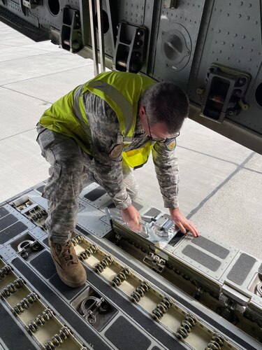 A NATO Air Transportation personnel installs the K-Wedge on the floor of a Heavy Airlift Wing C-17 Globemaster III at Papa Air Base, Hungary, Feb. 27, 2024. The K-Wedge is an installable C-17 loading aid and low-cost solution that eliminates preventable damage during cargo loading operations. (U.S. Air Force photo by Senior Master Sgt. Brett Kiser)