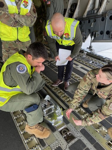 U.S. Air Force Staff Sgt. Sydney McDougal, C-17 Globemaster III loadmaster assigned to the Heavy Airlift Wing, gives K-Wedge prototype design feedback to Bunker Supply’s Chief Executive Officer Ryan Olson and Chief of Staff of the Air Force Strategic Studies Group’s Lt. Col. Michael Ristom at Papa, Air Base, Hungary, Feb. 28, 2024. The K-Wedge is an installable C-17 loading aid and low-cost solution that eliminates preventable damage during cargo loading operations. (U.S. Air Force photo by Senior Master Sgt. Brett Kiser)