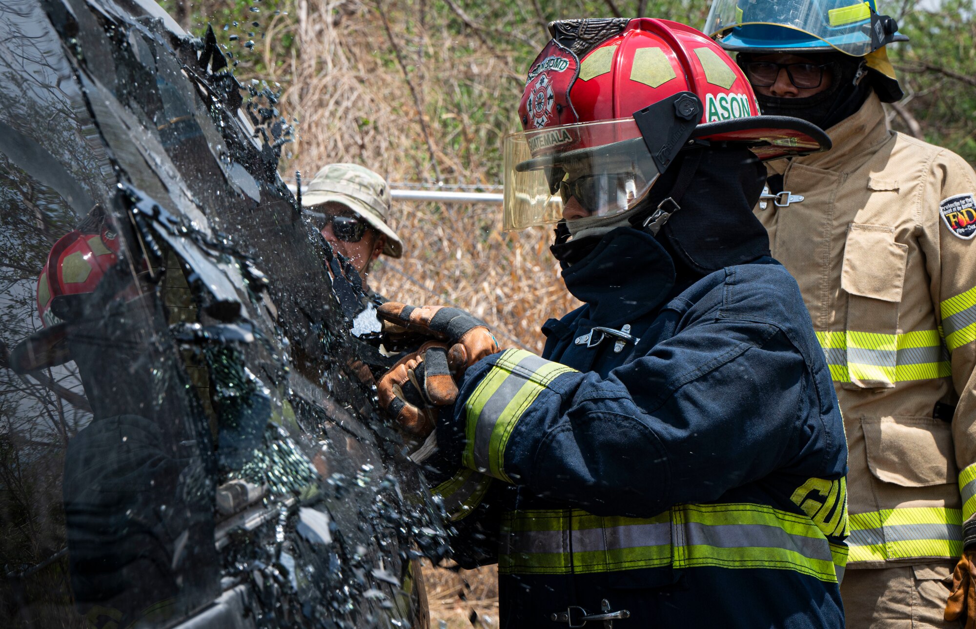 A photo of a firefighter smashing a window.